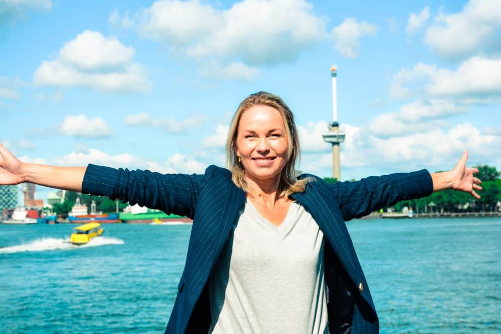 Leiderschap zonder ego vrouw met uitgestrekte armen voor erasmusbrug
