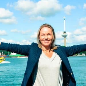 Leiderschap zonder ego vrouw met uitgestrekte armen voor erasmusbrug